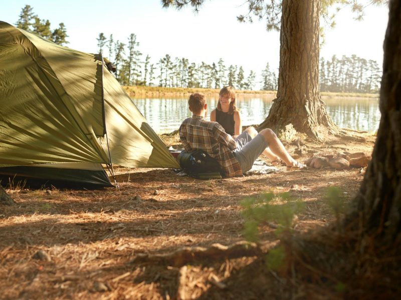 Shot of a young couple camping by a lake.