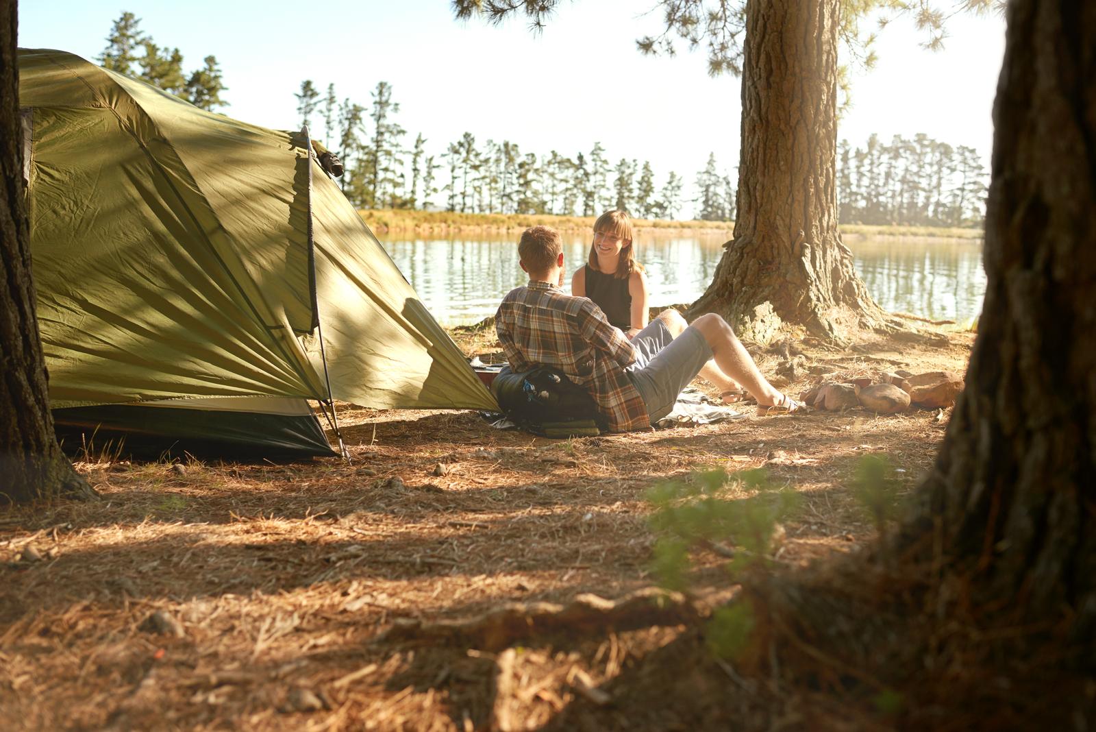 Shot of a young couple camping by a lake.
